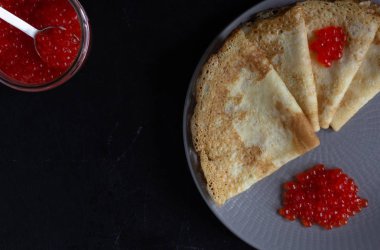 Blini üçgenler veya krep kavanoz ile plaka üzerinde kırmızı havyar ile
