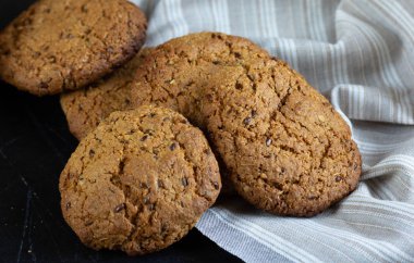 Keten peçete ile sepet içinde ev yapımı yulaf ezmesi çerezleri