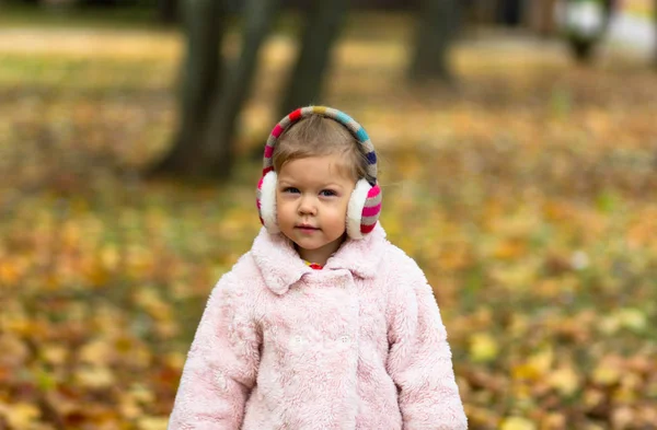 Hermosa niña sonriente en el parque de otoño mirando a la cámara —  Fotos de Stock