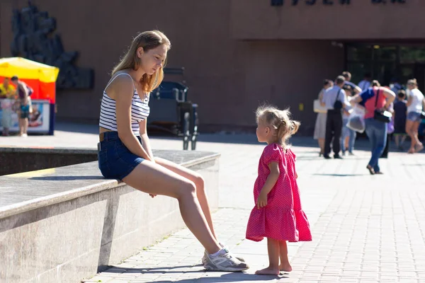 Küçük kız açık havada mutsuz ve üzgün genç anne