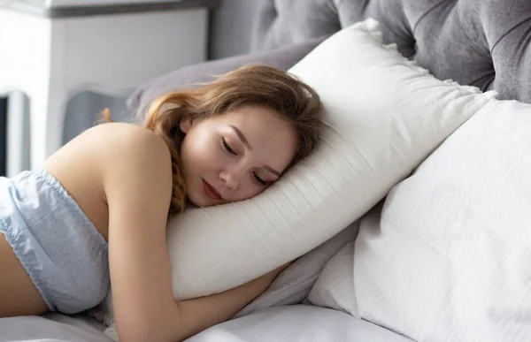 Young woman sleeping on pillow in bedroom