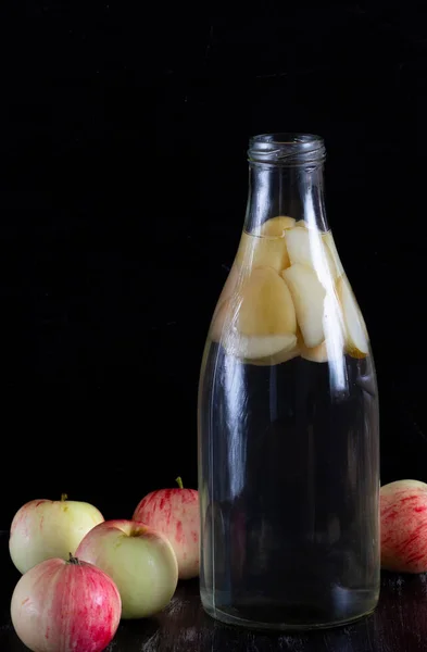Äpple kompott i glas flaska på svart bakgrunden — Stockfoto