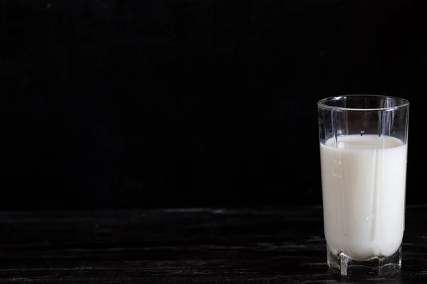 黒い背景に水差しのミルク — ストック写真