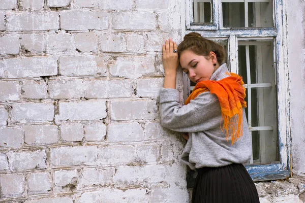 Молодая женщина с оранжевым шарфом на белом фоне — стоковое фото