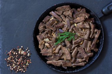 Siyah arka plan üzerinde tavada pişmiş karaciğer