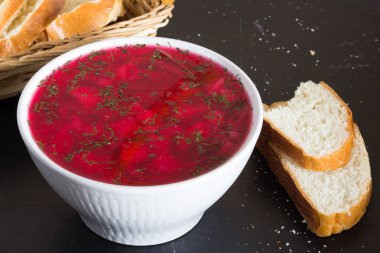 Pancar çorbasını siyah arka planda beyaz kâseye koy.