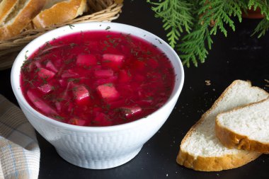 Pancar çorbasını siyah arka planda beyaz kâseye koy.