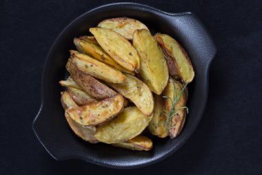 Siyah arka planda siyah tabakta biberiyeli kızarmış patateslerin üst görüntüsü