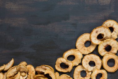 Kahverengi arka planda kurumuş elmayla düz uzanmış.