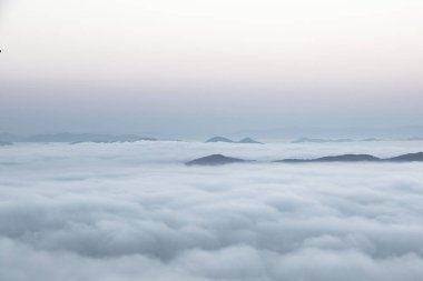 Sabah erken renkli sis aracılığıyla görünür siluetleri ile dağ silsilesi.
