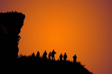 Güneşin doğuşunu bekleyen karanlık tepelerde üstüne kadar çok insan siluetleri.