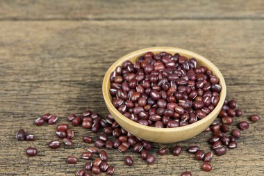 Ahşap masa arkasındaki tahta kasede çiğ fasulye tohumu..