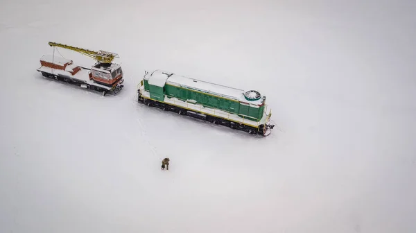 Train in snow. Cold Ukrainian winter and lonely train in a middle of nowhere. everything white and frozen. Aerial view.