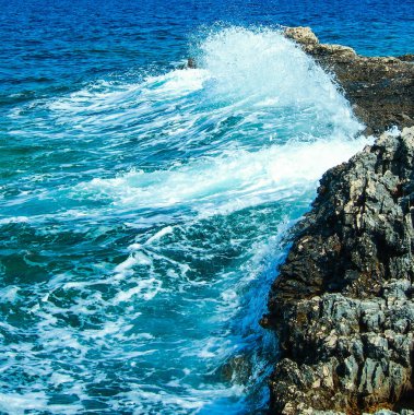 mavi deniz dalgası kayalara çarpıyor