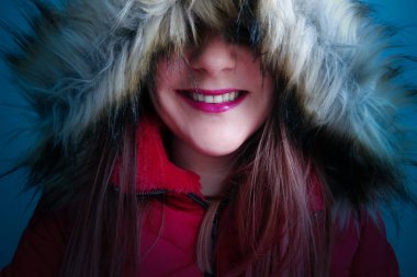 Kırmızı bir kış ceket içinde gülümseyen kadın