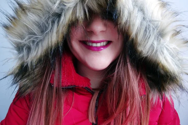 Kırmızı bir kış ceket içinde gülümseyen kadın