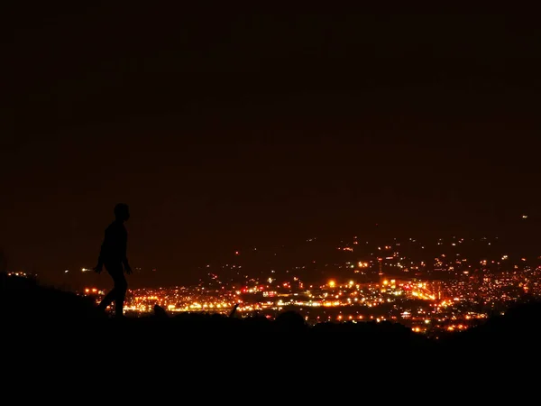 Boy Silhouette Contra Pano Fundo Uma Paisagem Urbana Noturna — Fotografia de Stock