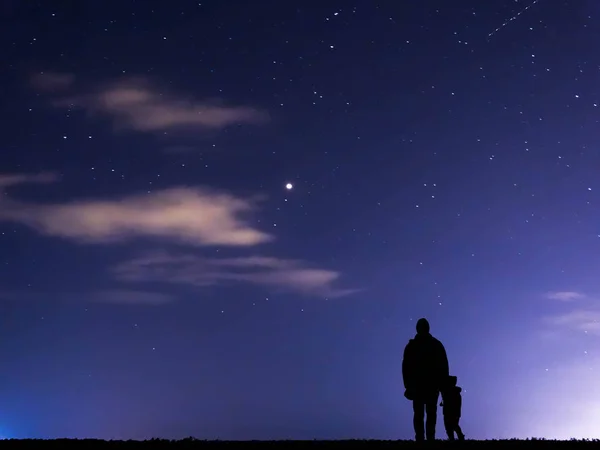 Baba ve oğul siluetleri Blue Night arka plan karşı 