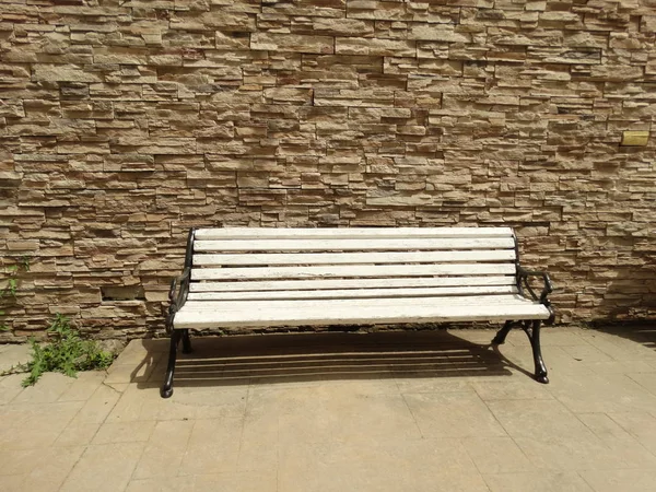 Lege Witte Bench Voor Een Bakstenen Muur — Stockfoto
