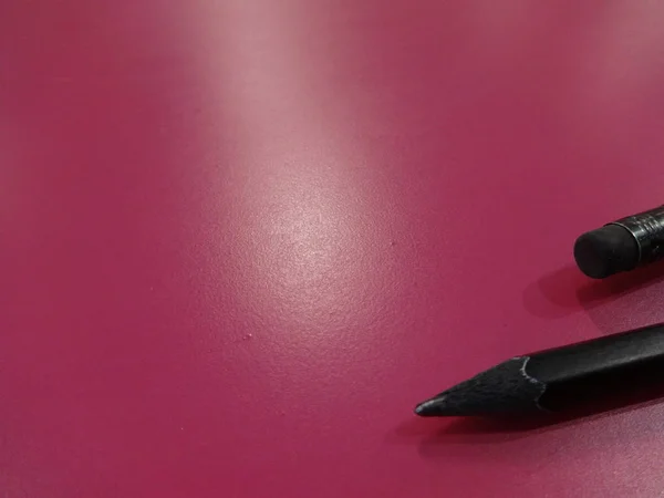 ピンク色の背景に黒いペン — ストック写真
