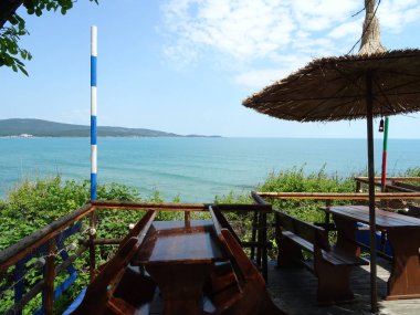 Deniz manzaralı bir restoran bir saman tente şemsiye ile gelen