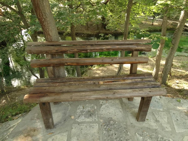 川の背景に木製のベンチ — ストック写真