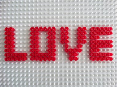 İzole kırmızı aşk metin plastik oyuncak boncuklar yapılmış