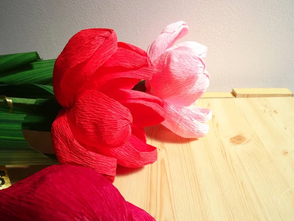 Red and Pink Handmade Paper Flowers on Wooden Background