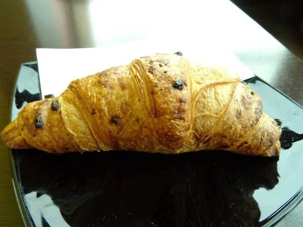 Croissant Einem Schwarzen Teller — Stockfoto