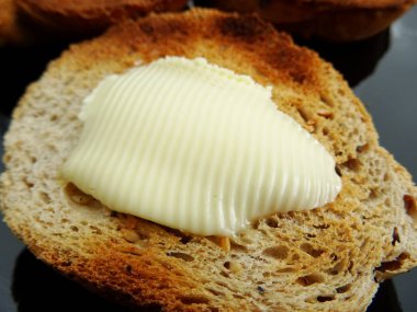 Kızarmış ekmek dilimi üzerine tereyağı erime
