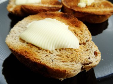 Kızarmış ekmek dilimi üzerine tereyağı erime