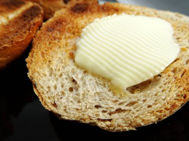 Kızarmış ekmek dilimi üzerine tereyağı erime