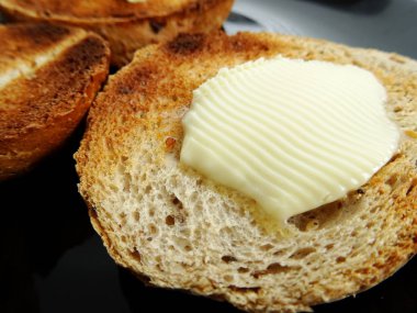 Kızarmış ekmek dilimi üzerine tereyağı erime