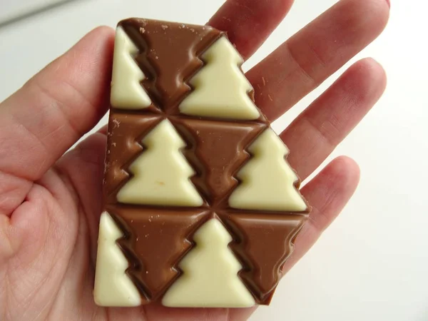 Mão Segurando Chocolate Branco Marrom Uma Forma Árvore Natal — Fotografia de Stock