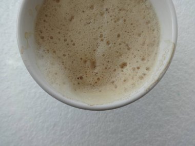 Kapuçino beyaz arka plan üzerinde beyaz bir kupa köpük ile