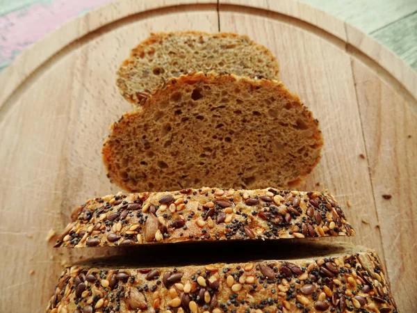 Φέτες Ψωμί Σουσάμι Και Σπόρους Σανίδα Κοπής Ψωμιού Από Ξύλο — Φωτογραφία Αρχείου