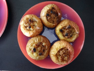 Pembe bir tabak içinde doldurma ile pişmiş elma