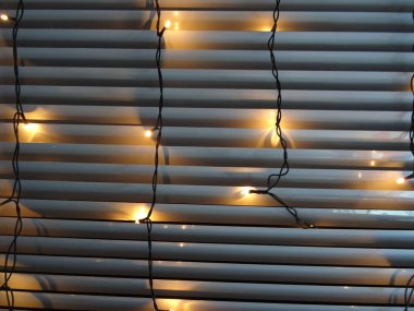 Jaluzi üzerinde sarı Noel ışıkları