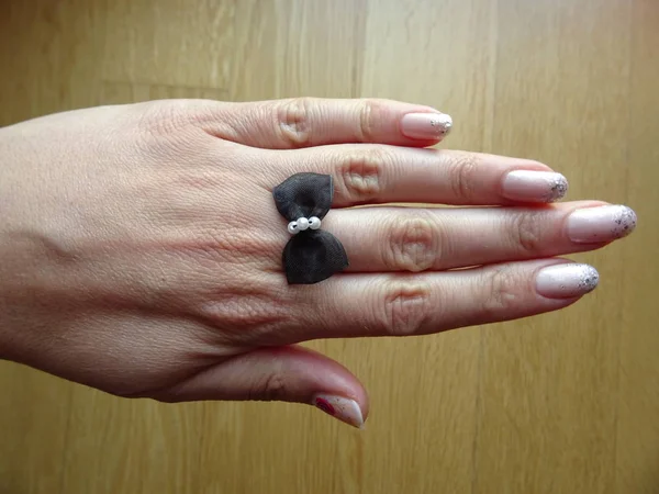 Μικρό Μαύρο Φιόγκο Δαχτυλίδι Ένα Γυναικείο Δάχτυλο — Φωτογραφία Αρχείου