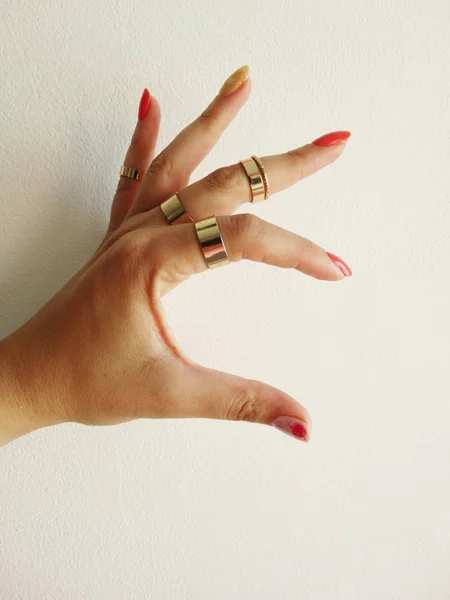 Ręka Czerwonymi Złotymi Paznokci Sztuki Złote Pierścienie — Zdjęcie stockowe