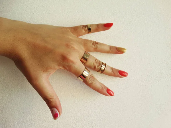 Female Hand Red Gold Nail Polish Art Golden Rings — Stock Photo, Image