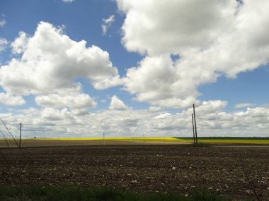 Sürülmüş toprak beyaz bulutlar ile mavi gökyüzünün altında yatay