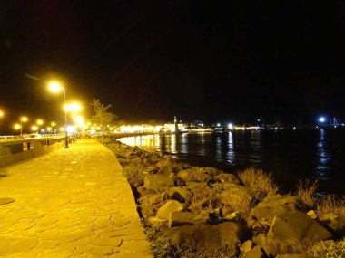 Deniz suyu yansıtan gece şehir ışıkları