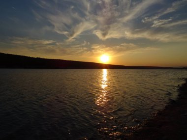 Bir göl üzerinde dramatik günbatımı gökyüzü