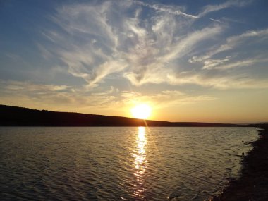 Bir göl üzerinde dramatik günbatımı gökyüzü