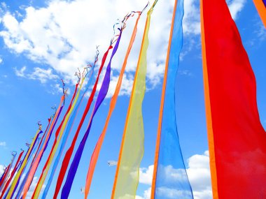 Gökyüzü arka plana karşı renkli dikey bayraklar