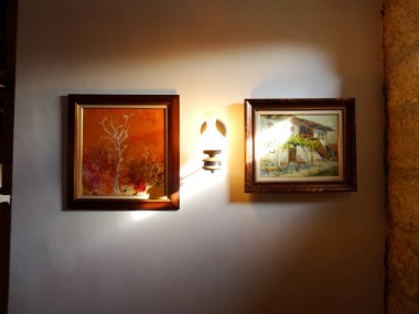Bir duvarda asılı çerçeve içinde Resim Sergisi