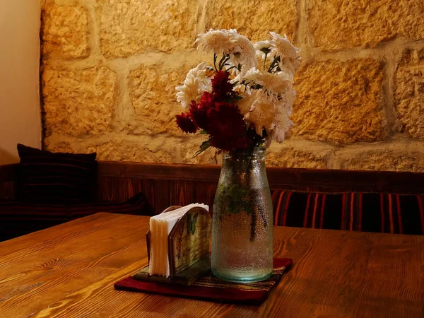 在保加利亚本土餐厅的桌子上与鲜花一起花瓶 — 图库照片