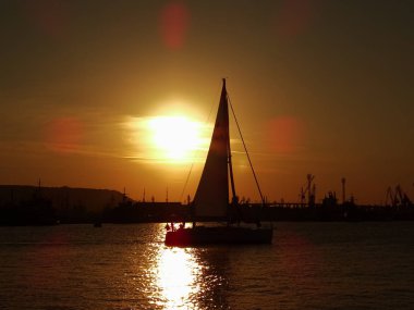 gün batımında denizde küçük tekne