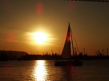 gün batımında denizde küçük tekne